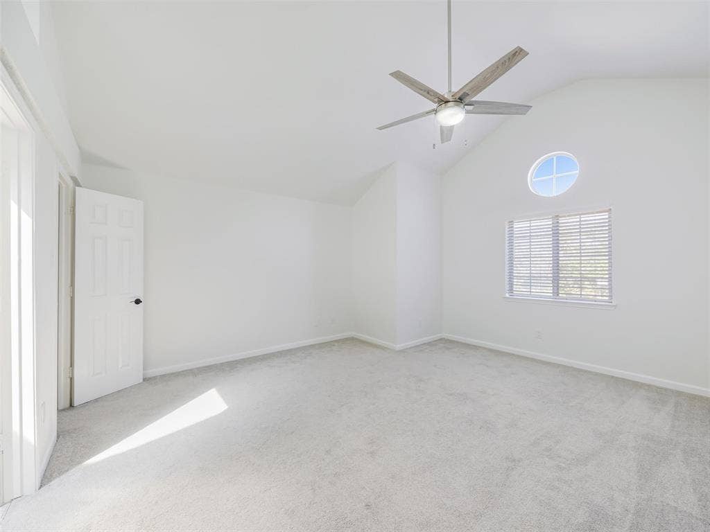 2327 N Ridge Road, McKinney, TX 75072 Vaulted ceiling with an integrated ceiling fan, light-toned carpeting, and a round accent window