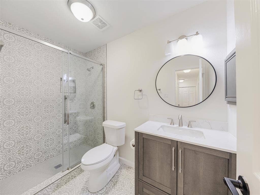 2327 N Ridge Road, McKinney, TX 75072 Glass-enclosed shower with patterned tile surround, built-in shower bench, and hexagonal tile flooring