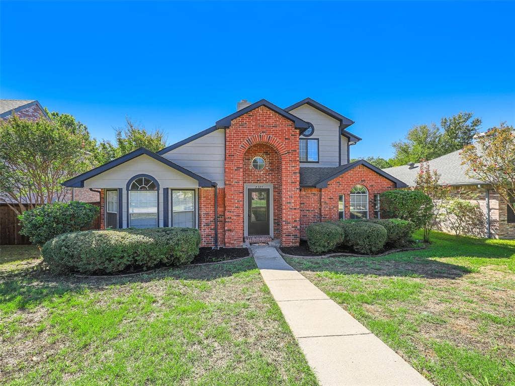 2327 N Ridge Road, McKinney, TX 75072 Brick and siding exterior with arched entry, arched windows, and mature shrubbery