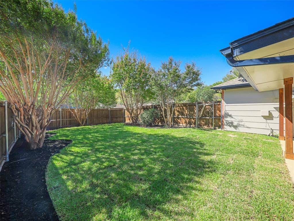 2327 N Ridge Road, McKinney, TX 75072 Expansive backyard with a manicured lawn, established trees, and a privacy fence