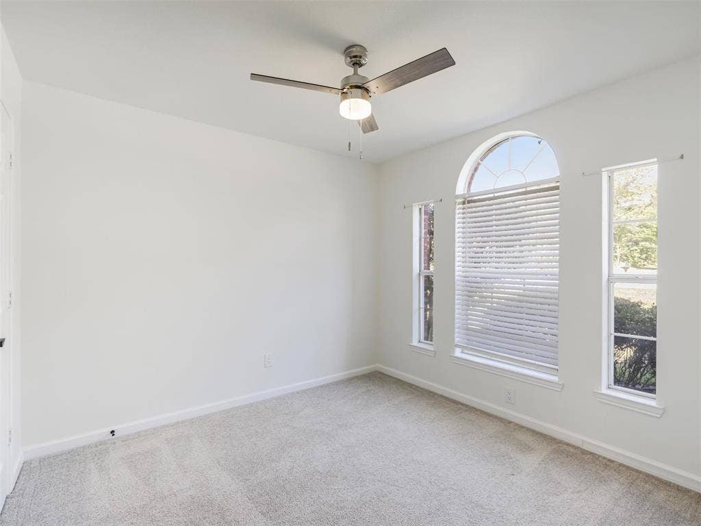 2327 N Ridge Road, McKinney, TX 75072 Arched window with two vertical windows, light grey carpeting, and a ceiling fan with integrated lighting