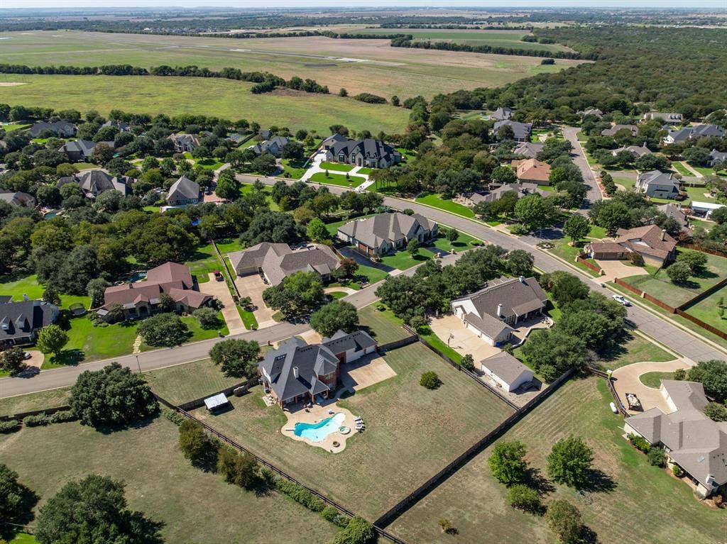 1021 Cascade Trail, McGregor, TX 76657 Residential neighborhood featuring multiple single-family homes, mature trees, and paved streets