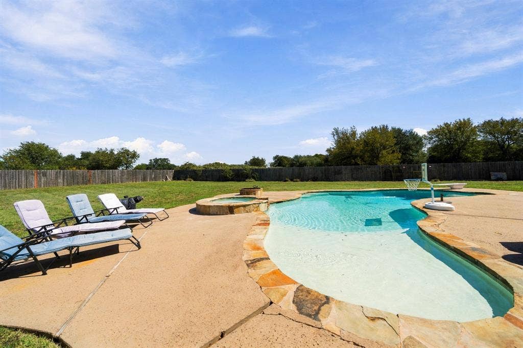 1021 Cascade Trail, McGregor, TX 76657 Freeform swimming pool with integrated spa and stone coping
