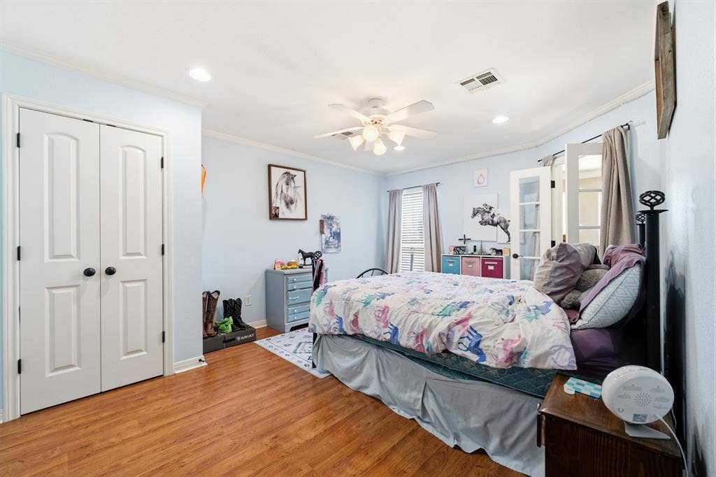 1021 Cascade Trail, McGregor, TX 76657 Wood-finish flooring, white bi-fold closet doors, recessed lighting, ceiling fan, and French doors