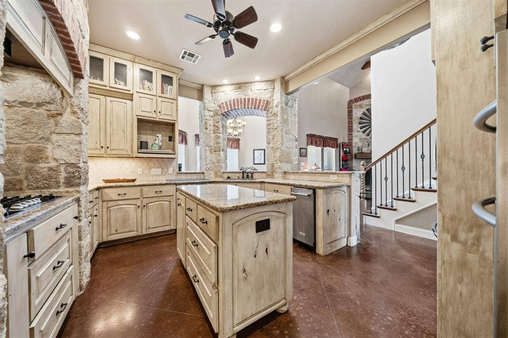 1021 Cascade Trail, McGregor, TX 76657 Kitchen featuring stone accent walls, a central island with a granite countertop, wood-finish flooring, recessed lighting, and a ceiling fan