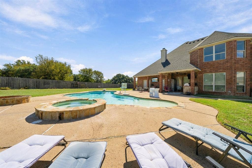 1021 Cascade Trail, McGregor, TX 76657 Custom freeform swimming pool with integrated spa and stone surround