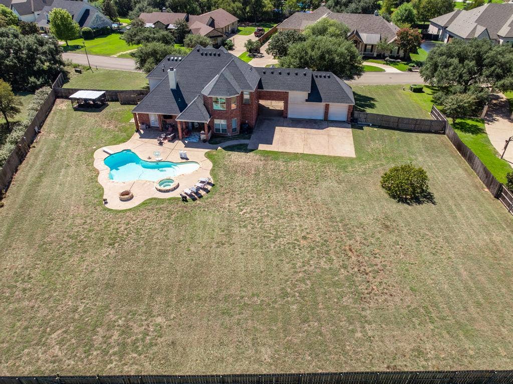 1021 Cascade Trail, McGregor, TX 76657 Brick exterior with a dark roof and multiple gables