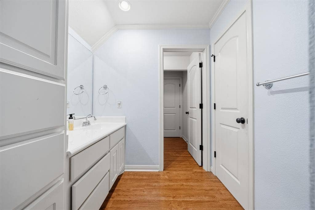 1021 Cascade Trail, McGregor, TX 76657 Vanity with integrated sink, white cabinetry, wood-finish flooring, and recessed lighting