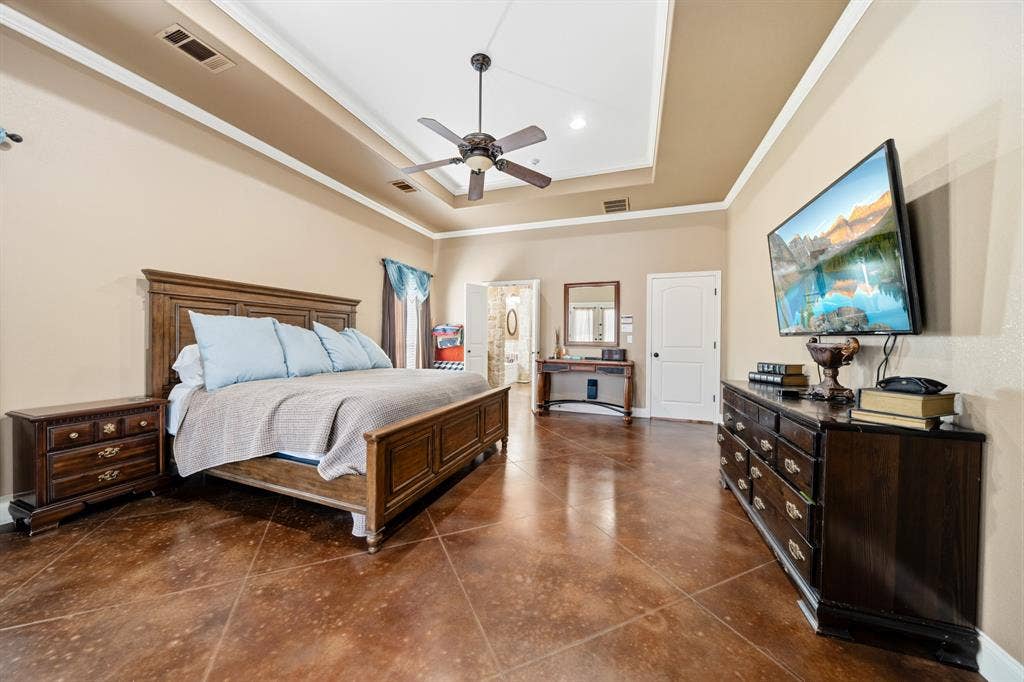 1021 Cascade Trail, McGregor, TX 76657 Tray ceiling with crown molding, ceiling fan, and tile flooring