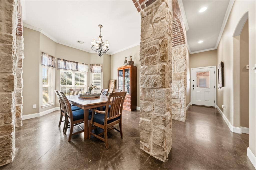 1021 Cascade Trail, McGregor, TX 76657 Stone archways, wood-finish flooring, recessed lighting, bay window, and a chandelier
