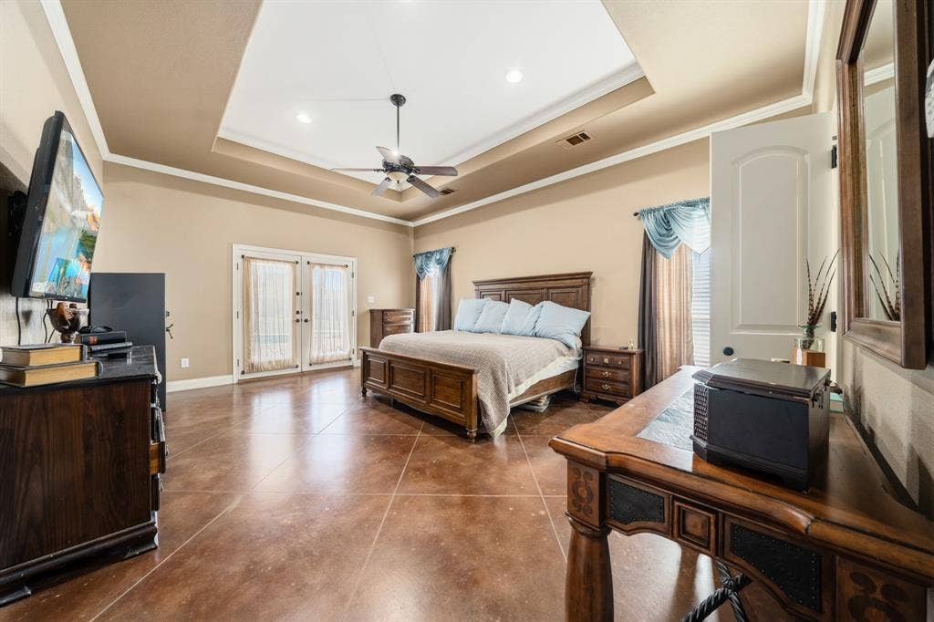 1021 Cascade Trail, McGregor, TX 76657 Tray ceiling with a ceiling fan, French doors, and polished concrete flooring