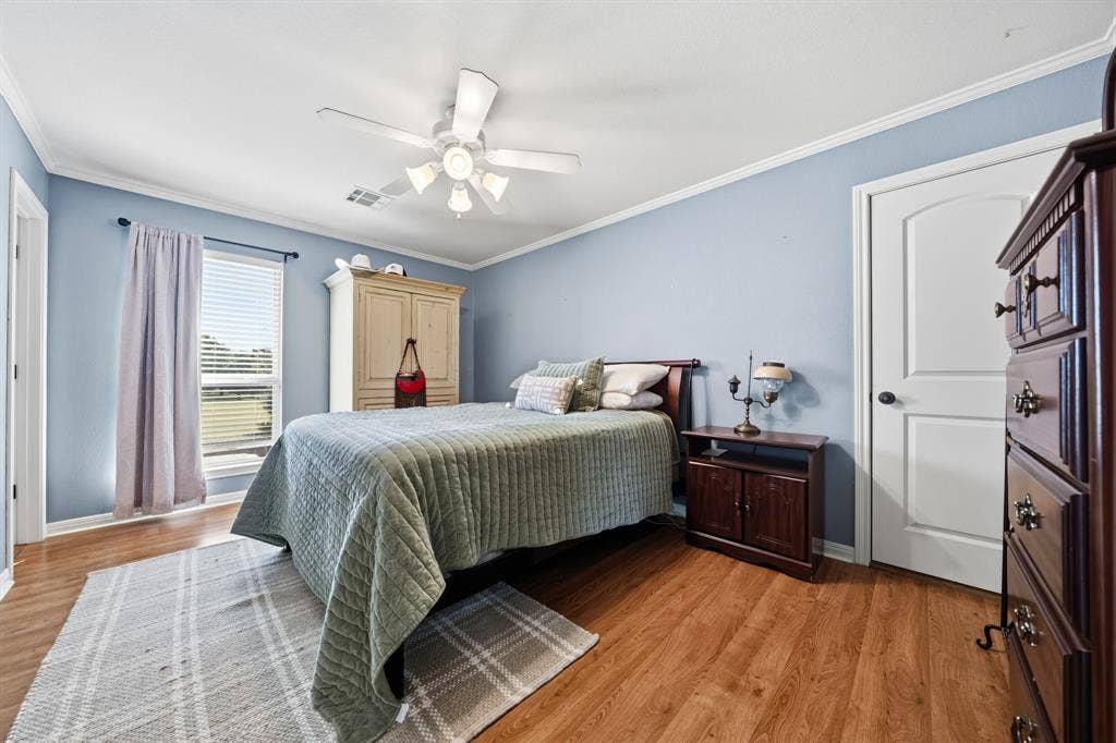 1021 Cascade Trail, McGregor, TX 76657 Wood-finish flooring, ceiling fan, white trim, and a window with blinds