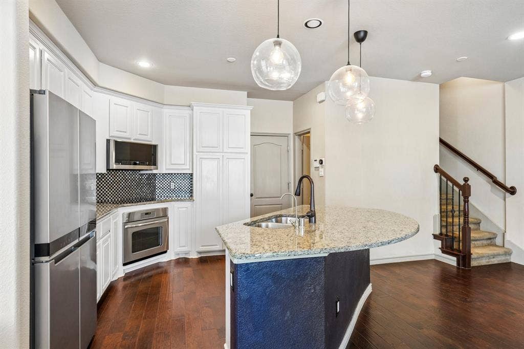 7937 Parkwood Boulevard, Plano, TX 75024 Gourmet kitchen featuring stainless steel appliances, white cabinetry, and granite countertops