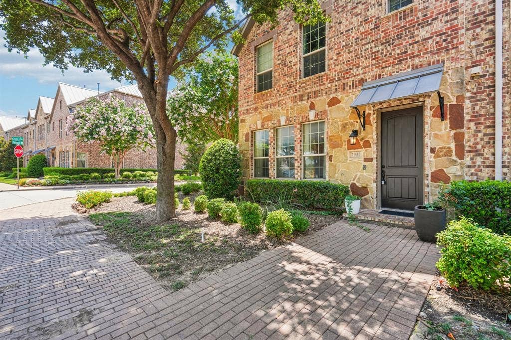 7937 Parkwood Boulevard, Plano, TX 75024 Brick and stone exterior with a dark paneled entry door and metal awning