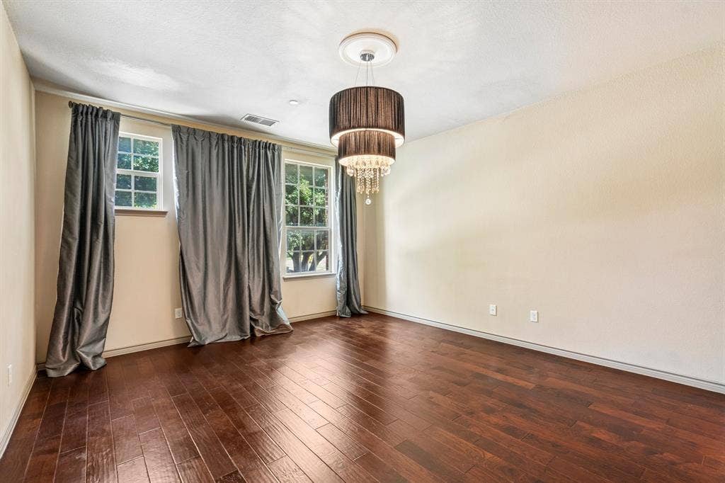 7937 Parkwood Boulevard, Plano, TX 75024 Hardwood flooring, two windows with grid patterns, and a tiered chandelier