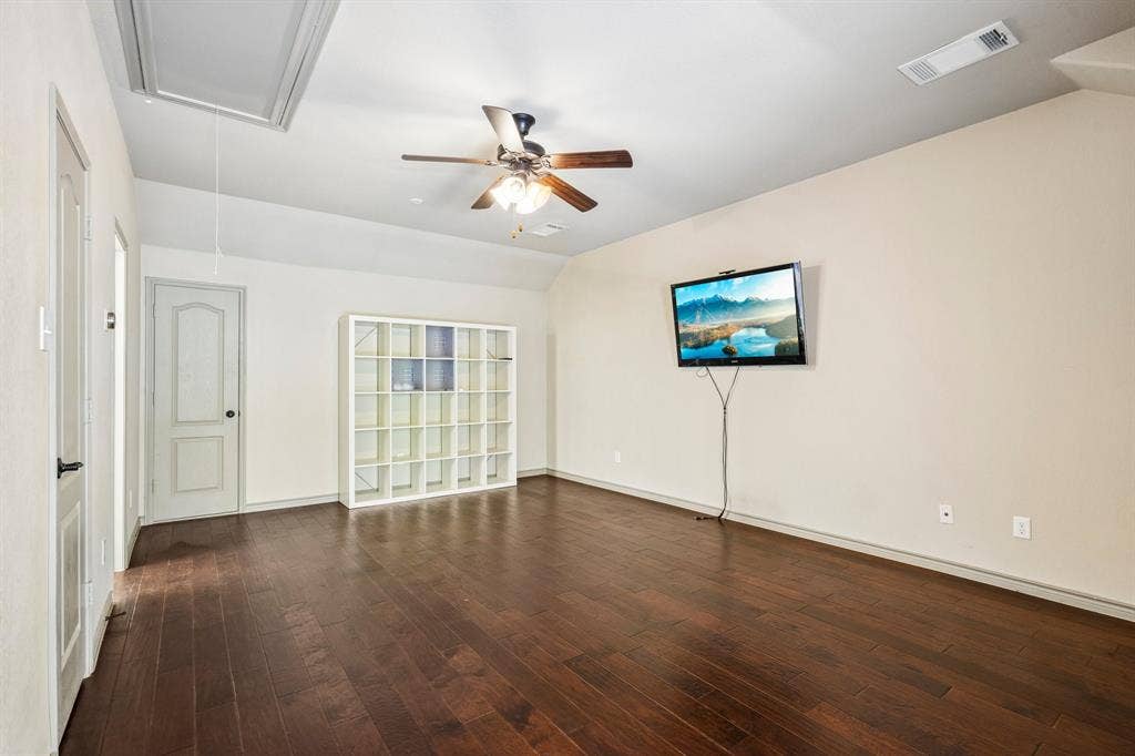 7937 Parkwood Boulevard, Plano, TX 75024 Wood-finish flooring throughout, ceiling fan with integrated lighting, and white built-in shelving unit