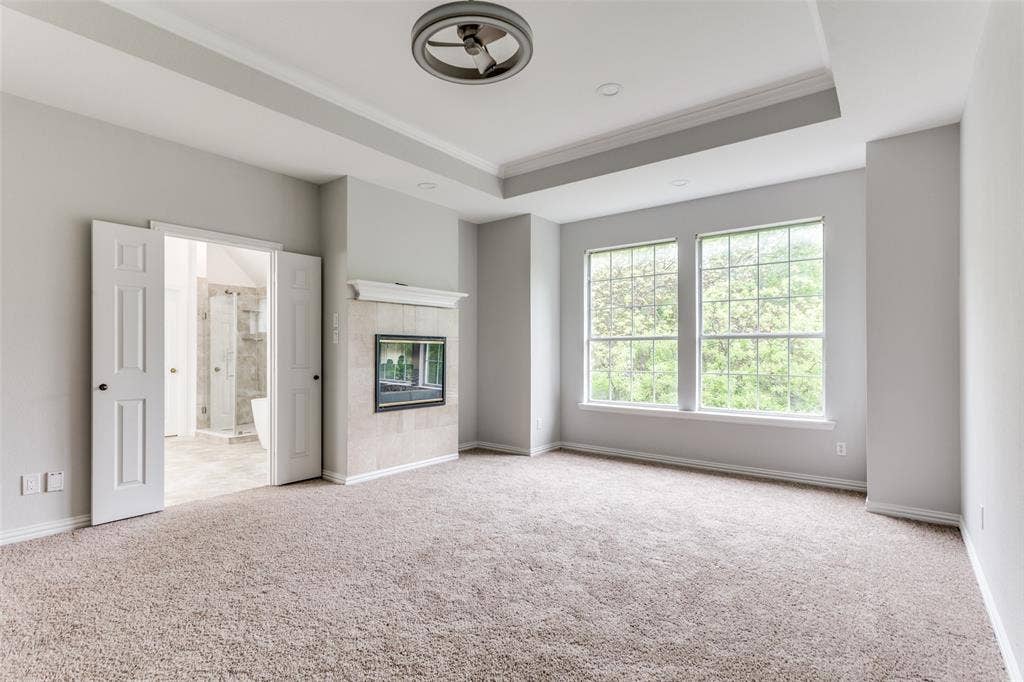 6315 Millwood Court, Arlington, TX 76016 Recessed lighting, tray ceiling, ceiling fan, carpeted flooring, and a fireplace with a tiled surround