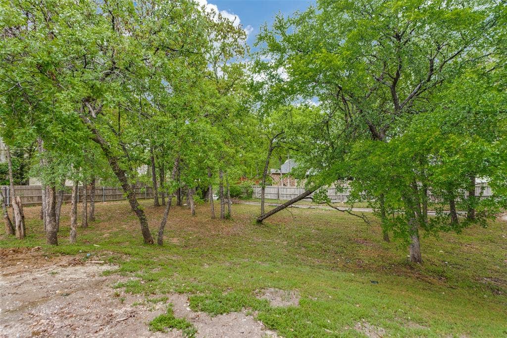 6315 Millwood Court, Arlington, TX 76016 Expansive outdoor area featuring mature trees and a partial wood fence
