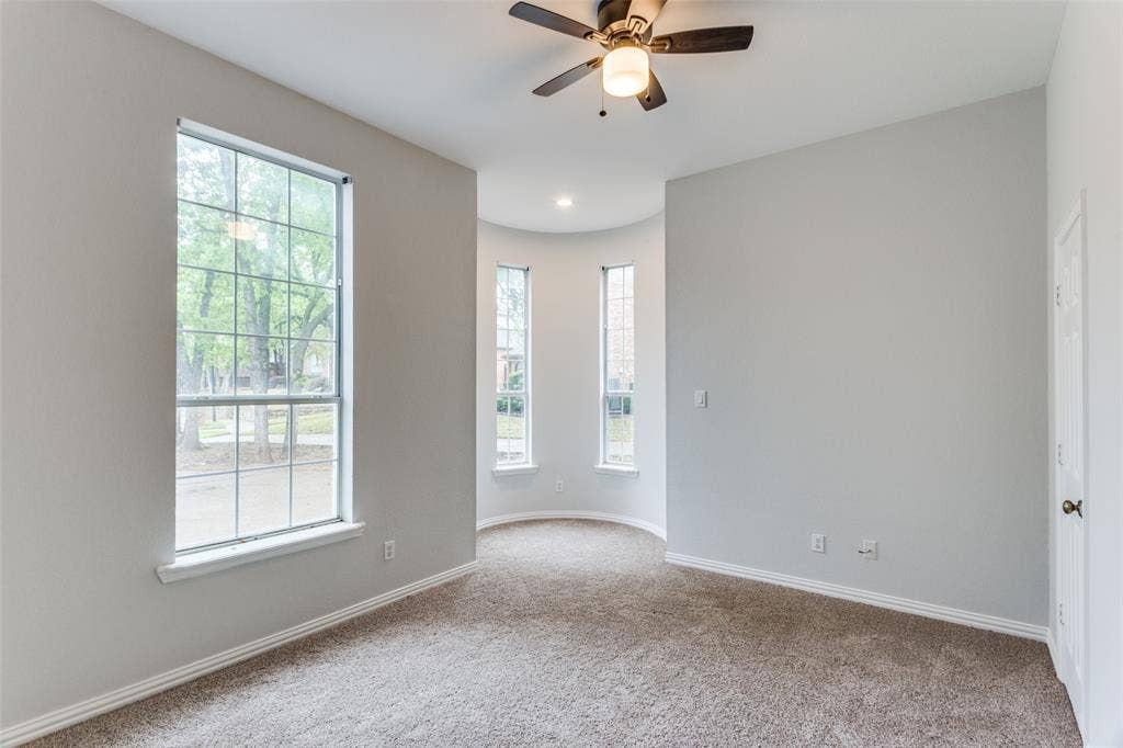 6315 Millwood Court, Arlington, TX 76016 Carpeted room featuring multiple windows, a ceiling fan with integrated lighting, and neutral wall tones
