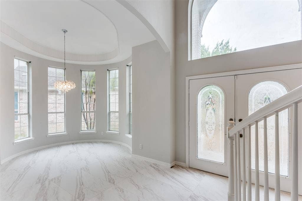 6315 Millwood Court, Arlington, TX 76016 Grand entry featuring double doors with decorative glass panels, a high arched window, and a white balustrade staircase