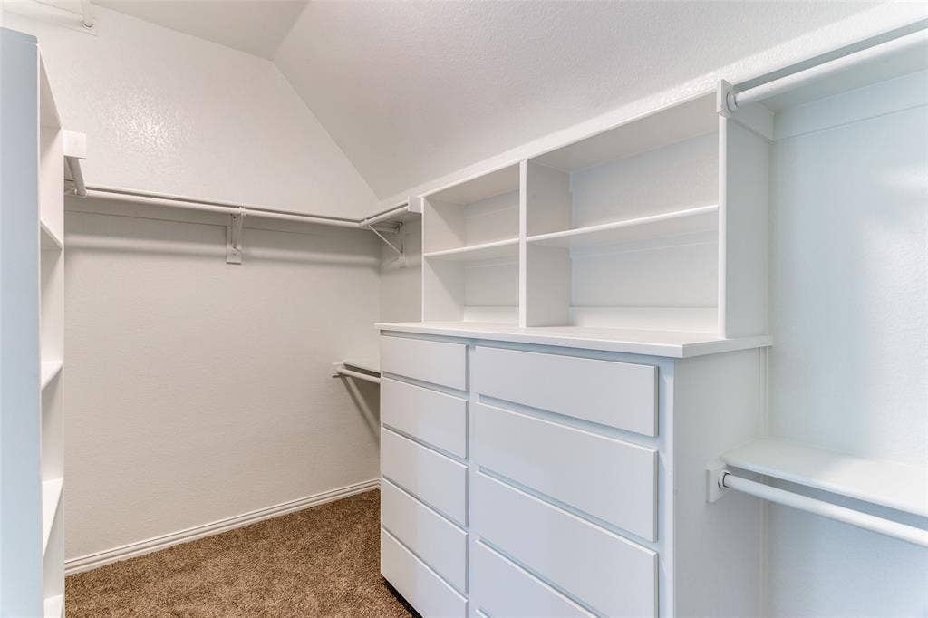 6315 Millwood Court, Arlington, TX 76016 Built-in white cabinetry, integrated shelving, multiple hanging rods, and light brown carpeting