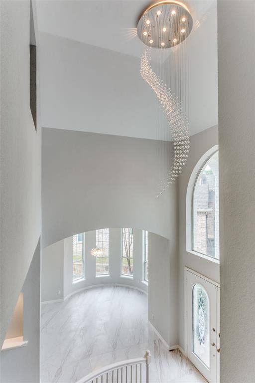 6315 Millwood Court, Arlington, TX 76016 Two-story foyer with a decorative chandelier, arched window, and custom glass-insert front door
