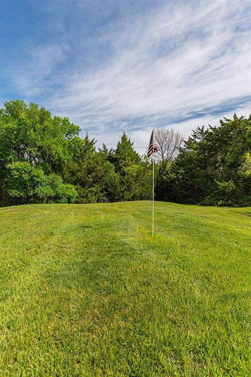 1603 Smirl Drive, Heath, TX 75032 Expansive manicured lawn with lush green turf and mature tree line backdrop