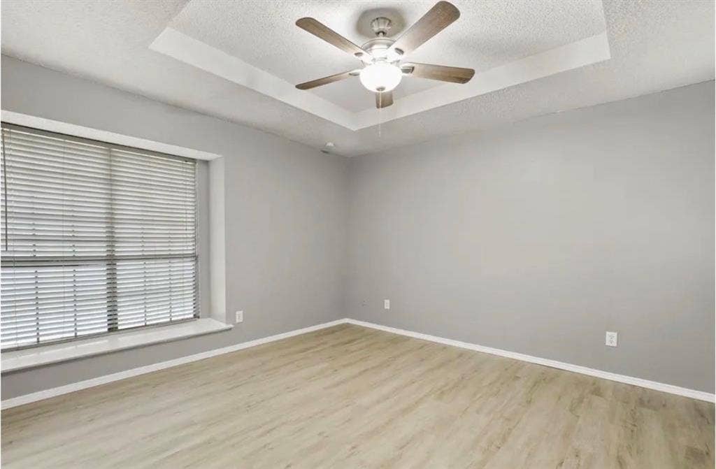 8943 Camfield Way, Frisco, TX 75033 Tray ceiling with a ceiling fan light fixture, wood-finish flooring, and a window with blinds