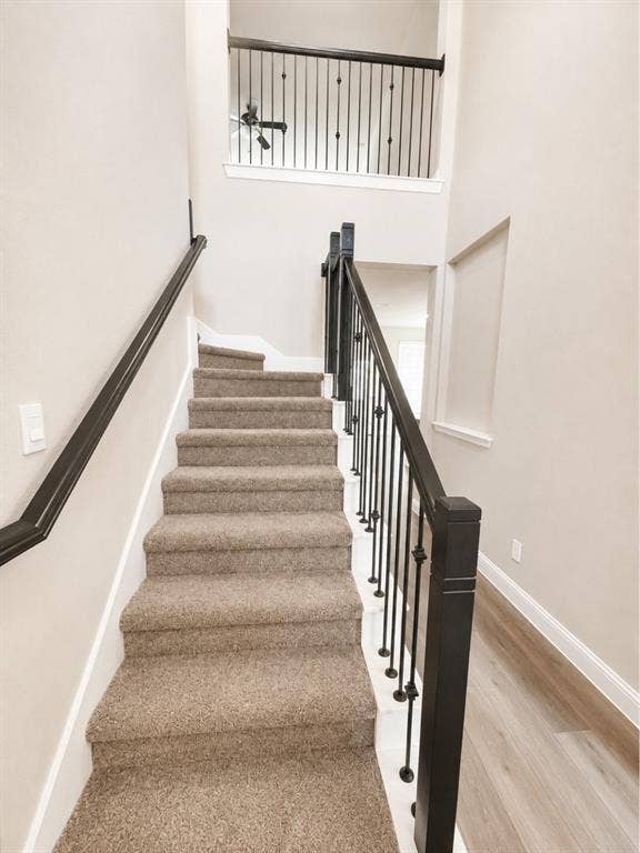 6002 14th Street, Midlothian, TX 76065 Carpeted staircase with black wrought iron balusters and dark wood newel posts