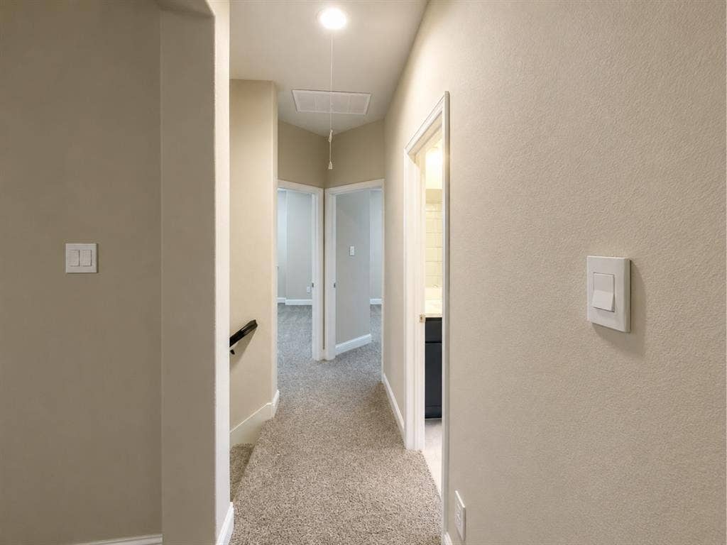 6002 14th Street, Midlothian, TX 76065 Carpeted hallway with light neutral walls, white baseboards, and multiple doorways leading to additional rooms
