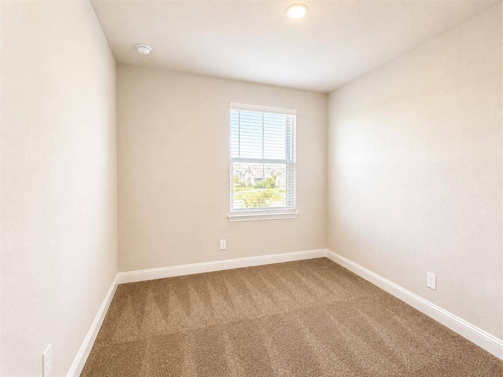 6002 14th Street, Midlothian, TX 76065 Neutral-toned walls complement the brown carpeted flooring