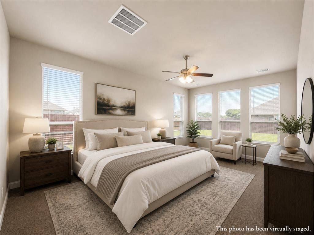 6002 14th Street, Midlothian, TX 76065 Bedroom with multiple windows, neutral wall tones, textured carpeting, and a ceiling fan
