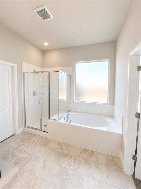 6002 14th Street, Midlothian, TX 76065 Bathroom featuring a built-in soaking tub, a framed glass shower enclosure, and light-toned tile flooring