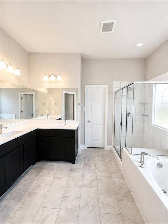 6002 14th Street, Midlothian, TX 76065 Spacious bathroom featuring an L-shaped vanity with dual undermount sinks, black cabinetry, and light-toned countertops