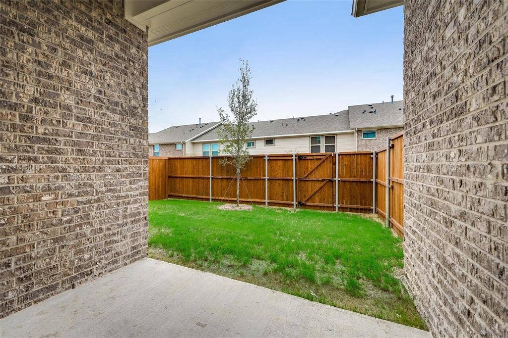 Private yard with a wood fence, concrete patio, and mature landscaping