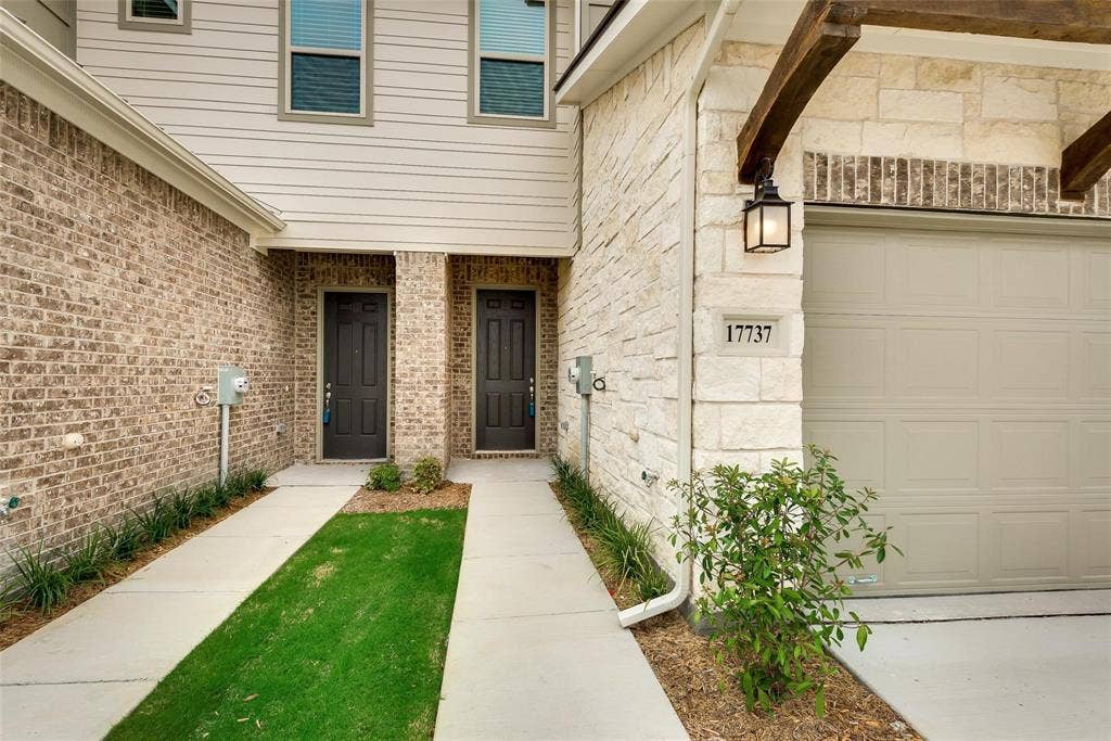Brick and stone exterior with decorative wood beams and a panel-style garage door