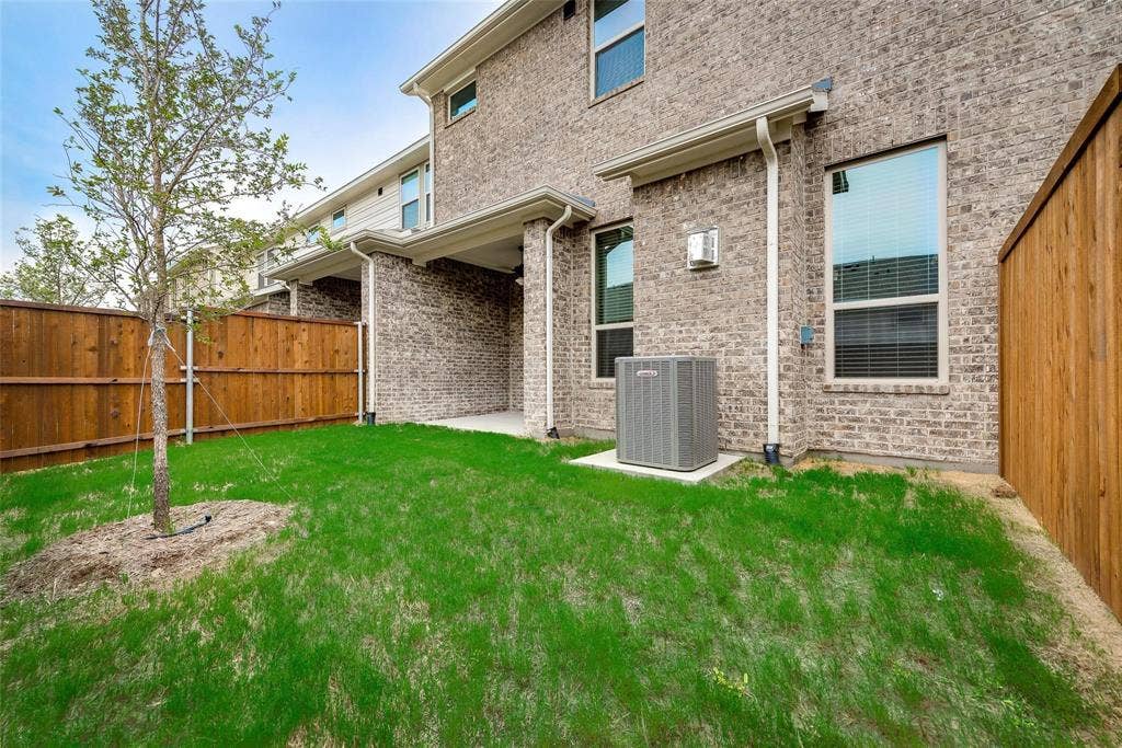 Private outdoor space with a grass lawn, privacy fencing, and a covered patio