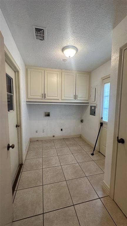 Tile flooring, ceiling-mounted light fixture, upper cabinetry, utility hookups, and exterior-access door to pool/yard and door to access garage.  Located just off the kitchen, separate room.