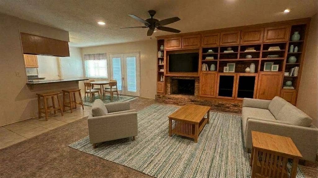 Staged AI furniture; Den area with Brick gas fireplace to use gas logs or wood, entertainment center for TV, books, other equip and pictures.