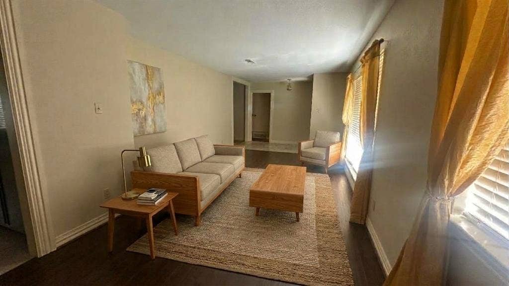 Staged AI furniture;  Living area featuring a floor-to-ceiling built-in wood cabinetry, brick fireplace, and a ceiling fan