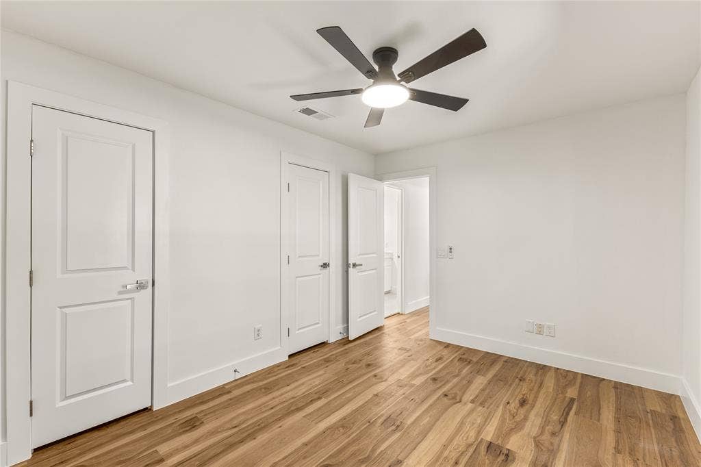 2716 Landershire Lane, Plano, TX 75023 Wood-finish flooring, white walls, two-panel interior doors, and a ceiling fan with integrated lighting