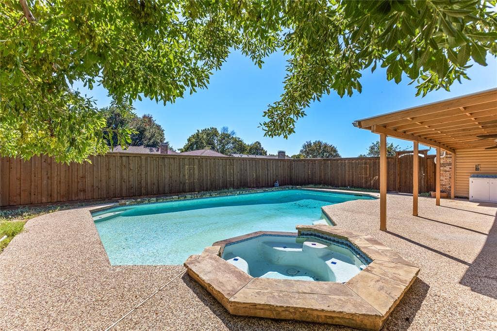 2716 Landershire Lane, Plano, TX 75023 Backyard oasis featuring a swimming pool, integrated spa, and expansive aggregate concrete patio