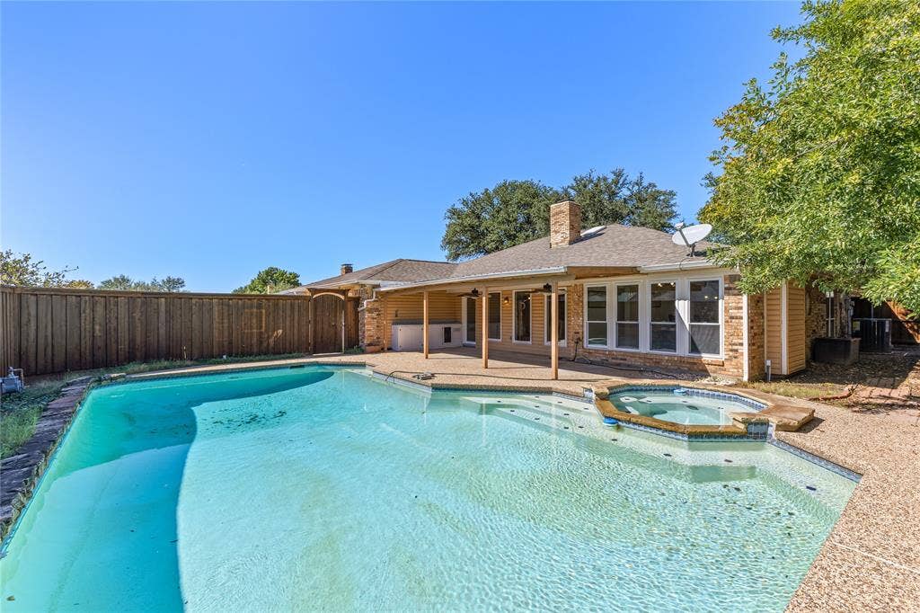 2716 Landershire Lane, Plano, TX 75023 Outdoor swimming pool with integrated spa and surrounding aggregate concrete decking