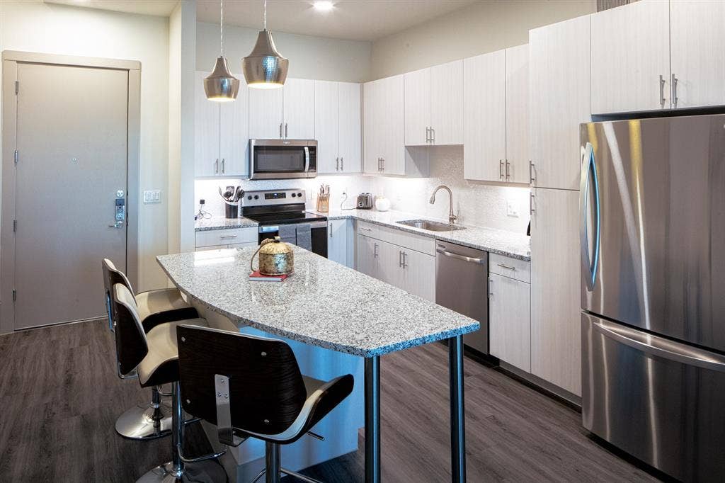 601 N Oak Street, #118, Roanoke, TX 76262 Kitchen featuring pendant lighting, white cabinets, sink, dark wood-type flooring, and appliances with stainless steel finishes