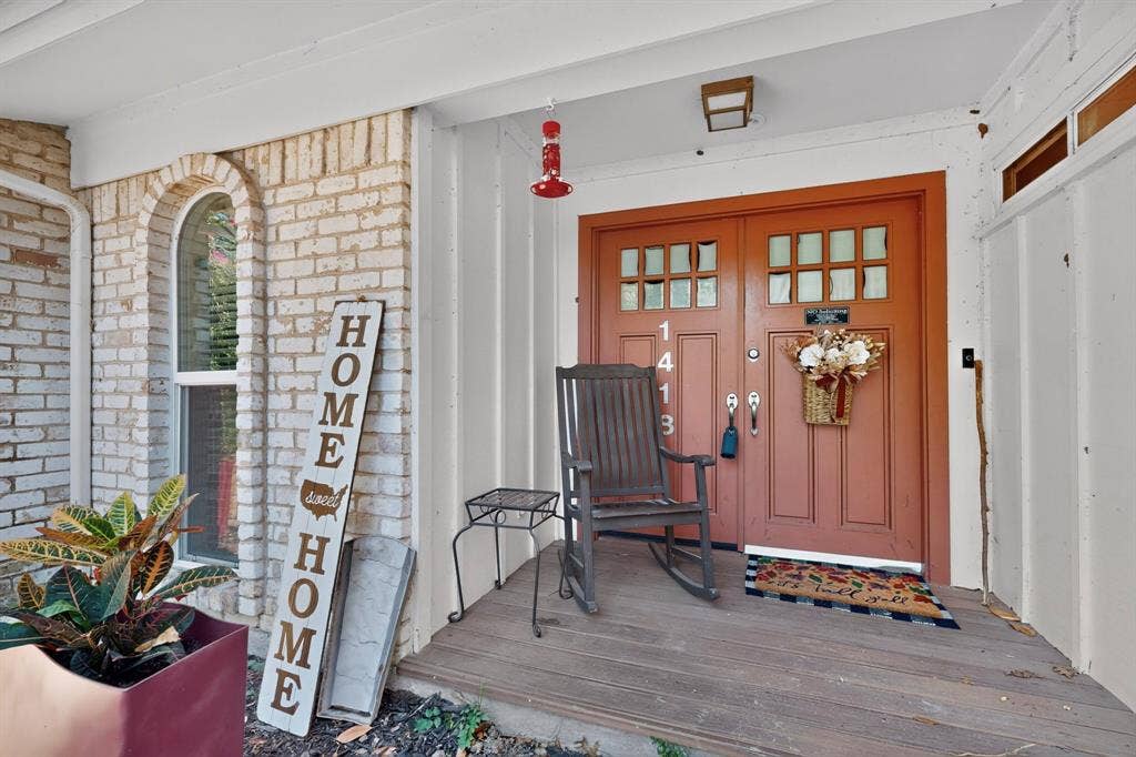 1418 Stony Brook Lane, Garland, TX 75043 Front entry featuring a double door with glass-paneled inserts, white brick facade, arched window, and a covered porch