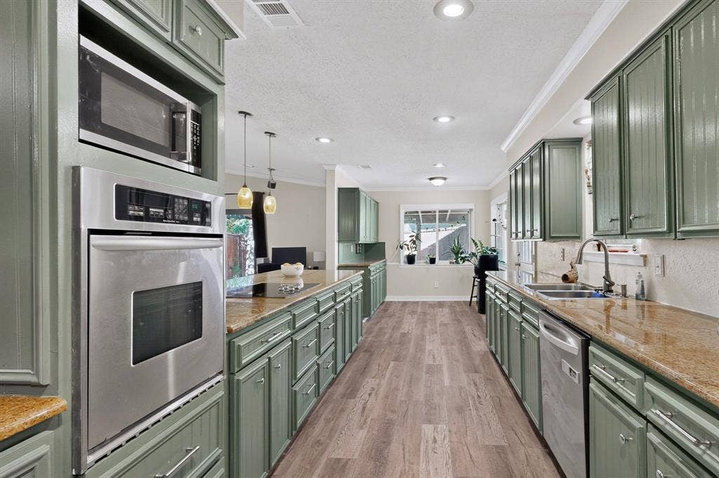 1418 Stony Brook Lane, Garland, TX 75043 Kitchen featuring extensive cabinetry, stainless steel appliances, granite countertops, wood-finish flooring, and recessed lighting