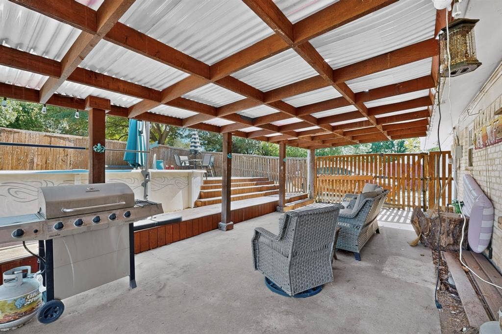 1418 Stony Brook Lane, Garland, TX 75043 Covered patio with a corrugated roof and exposed wood beams