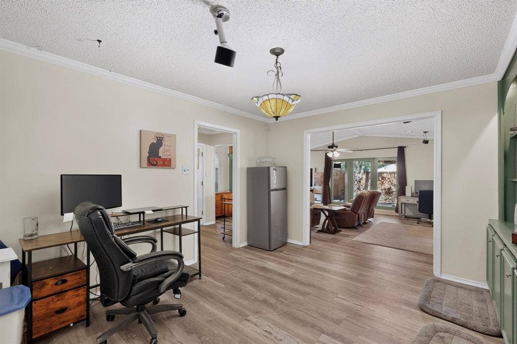 1418 Stony Brook Lane, Garland, TX 75043 Wood-finish flooring, crown molding, and a built-in display cabinet