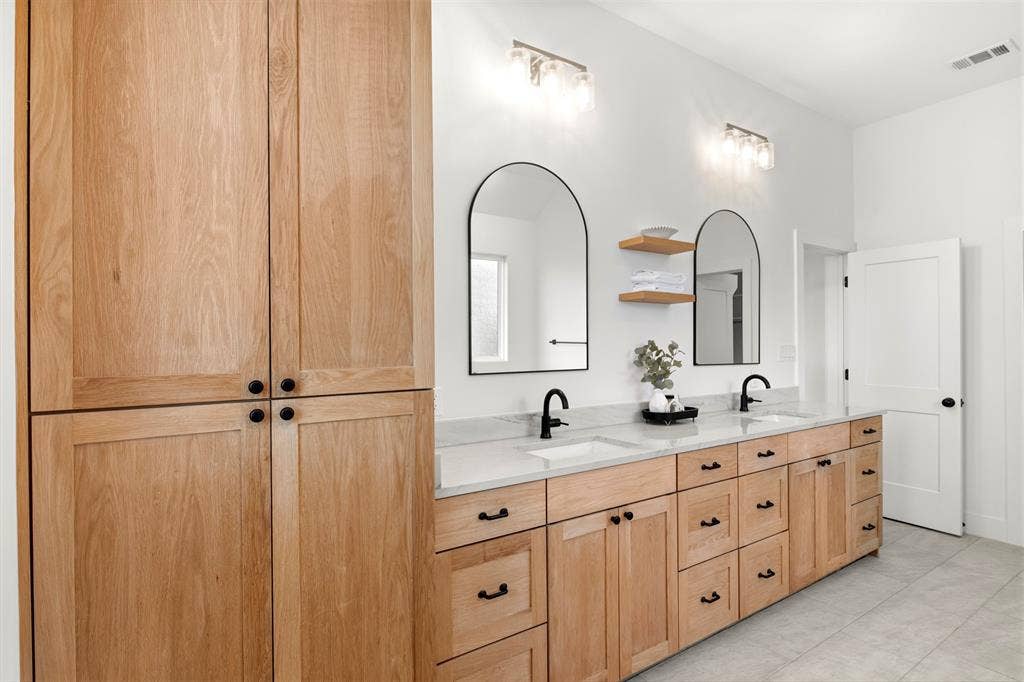 1220 Lynn Way, Waxahachie, TX 75165 Double vanity with natural wood cabinetry, ample counter space and storage.