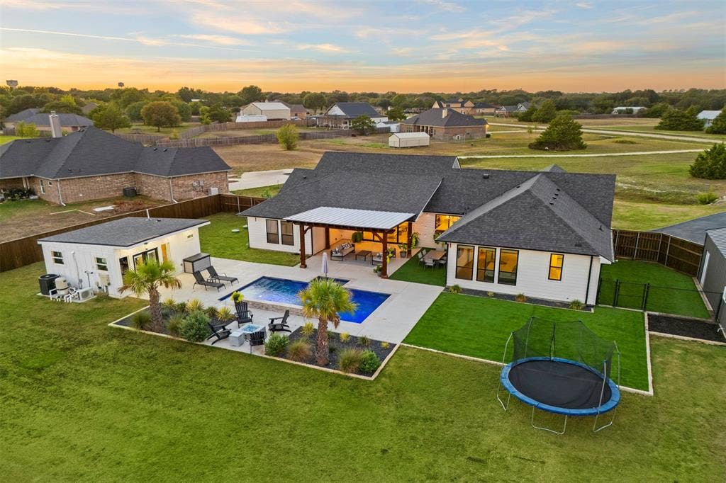 1220 Lynn Way, Waxahachie, TX 75165 Wide backyard view highlights the home's indoor-outdoor connection and separate structures.